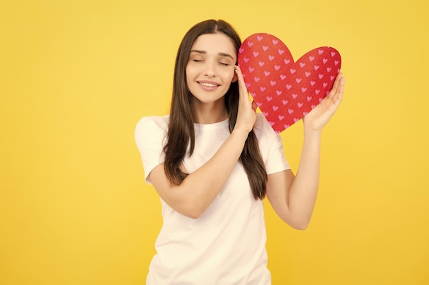 Mujer joven día de San Valentín concepto chica con tarjeta en forma de corazón encantadora chica encantadora sosteniendo en