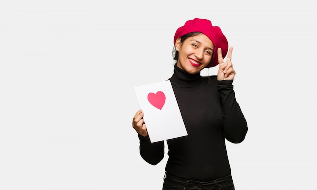 Mujer joven en el día de San Valentín divertido y feliz haciendo un gesto de victoria