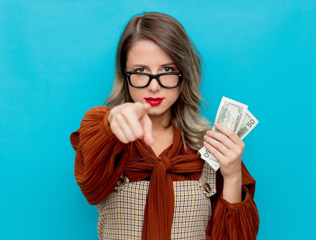 Mujer joven con dinero en mano en azul