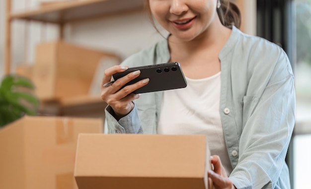 Mujer joven dirigiendo su negocio de ventas en línea desde casa tomando fotos de productos para la plataforma de comercio electrónico