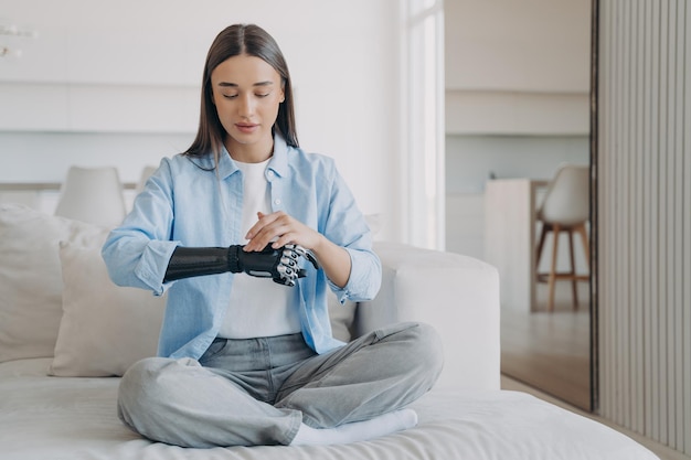 Mujer joven discapacitada está cambiando la configuración del brazo biónico en la mañana Mano de carbono de alta tecnología