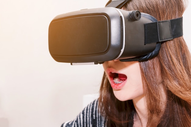 Mujer joven disfruta con gafas de realidad virtual en casa.