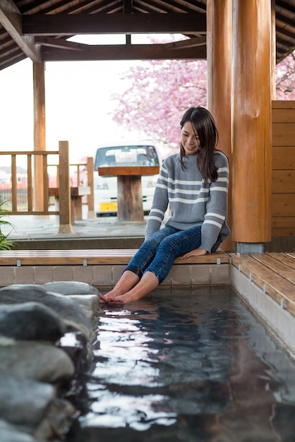 Mujer joven disfruta de onsen a pie