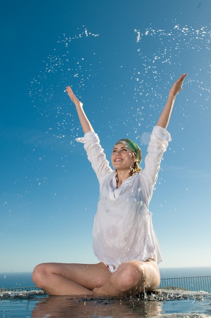 mujer joven disfrutando del agua bajo el sol