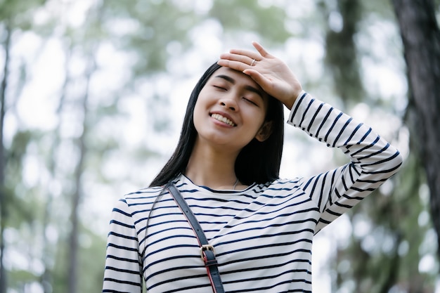 Mujer joven disfrutando del aire fresco en el bosque de pinos, relajación en concepto feliz de la naturaleza.