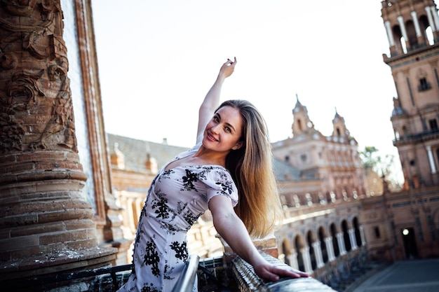 Mujer joven disfrutando y bailando en un balcón de la Plaza de España en Sevilla