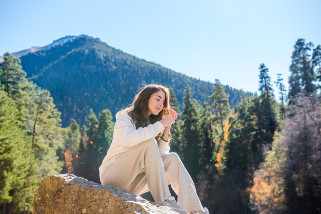 Mujer joven disfrutando de la belleza de la naturaleza de un río de montaña Chica turista en las montañas