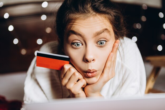 Mujer joven disfrutando de las compras en línea para Navidad.