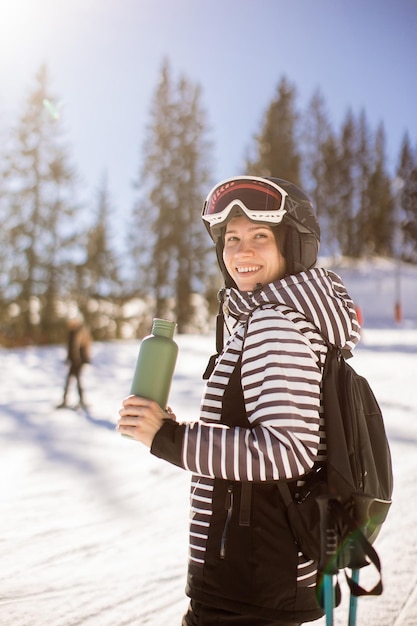 Mujer joven disfrutando del día de invierno de la diversión de esquí en la nieve