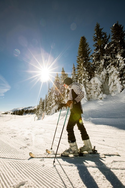 Mujer joven disfrutando del día de invierno de la diversión de esquí en la nieve