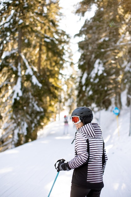 Mujer joven disfrutando del día de invierno de la diversión de esquí en la nieve