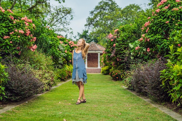 Mujer joven disfrutando de un hermoso jardín floreciente