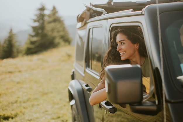 Mujer joven disfrutando de la libertad en un vehículo todoterreno en un día soleado