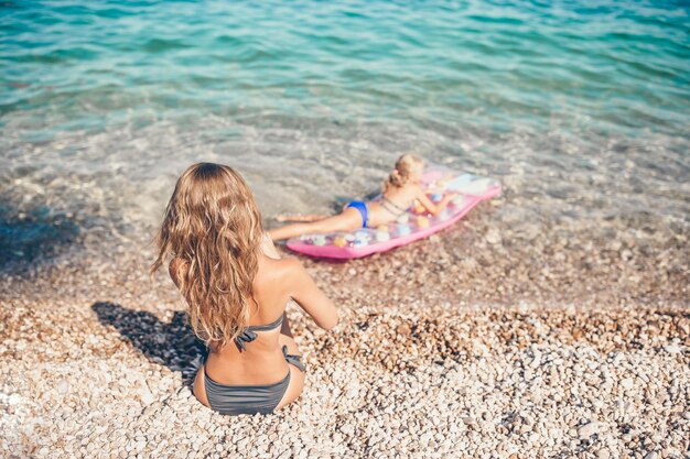 Mujer joven disfrutando del sol tomando el sol junto al mar turquesa perfecto