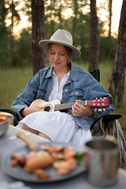 Foto mujer joven disfrutando del tiempo en el camping