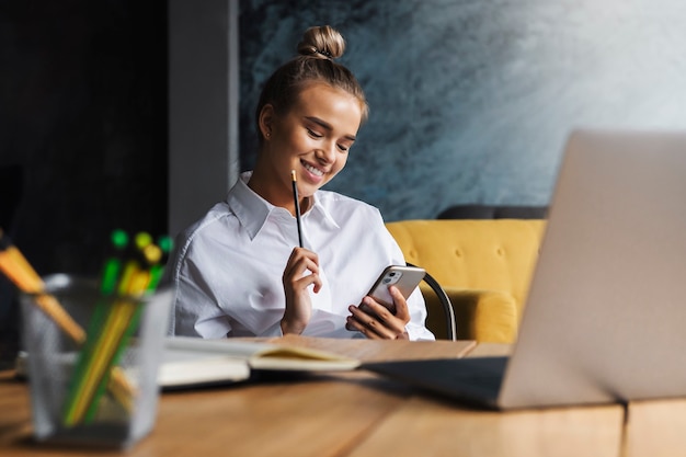 Foto mujer joven con dispositivos digitales para el trabajo.