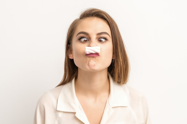 Mujer joven divertida con bigote tipo malvavisco de caramelo dulce. concepto de depilación y depilación