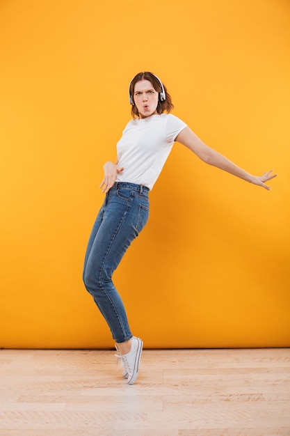 Mujer joven divertida emocional bailando aislado