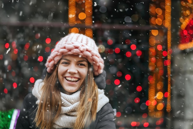 Mujer joven divertida jugando con luces brillantes en la calle. Espacio vacio