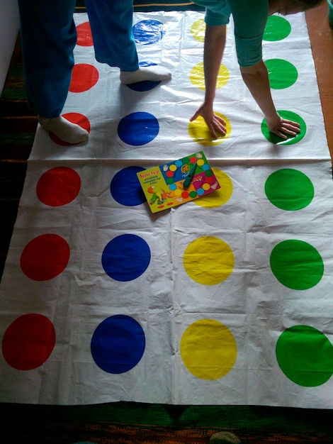 Foto mujer joven divirtiéndose mientras juega twister