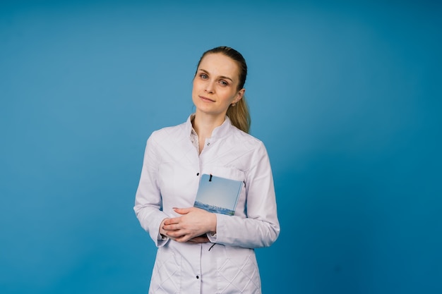 Mujer joven, doctor, en, blanco, bata de laboratorio, tiro del estudio