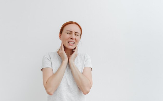 Mujer joven con dolor en la cabeza Dolor de garganta Dolor de muelas Dolor de cabeza migraña Fondo blanco