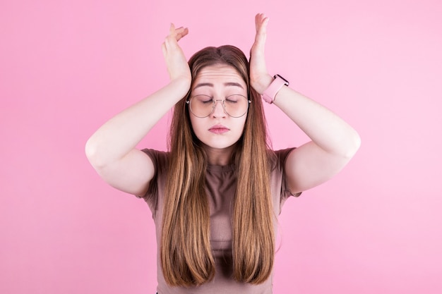 Foto mujer joven con dolor de cabeza sostiene sus sienes con las manos. salud, migraña y dolor de cabeza