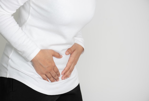 Foto mujer joven con dolor de estómago doloroso o dolor abdominal.