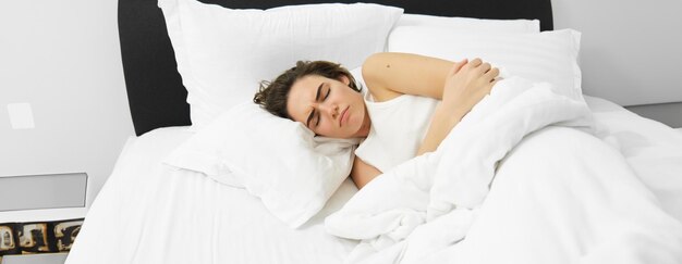 Foto mujer joven durmiendo en la cama en casa