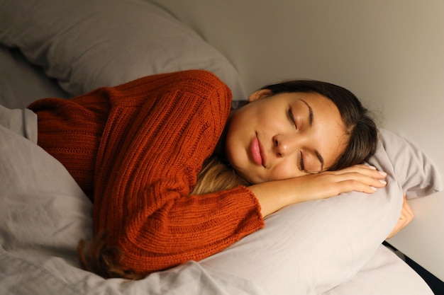 Mujer joven durmiendo pacíficamente en la cama