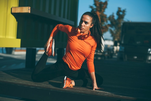 Mujer joven ejercicios en el paseo después de correr