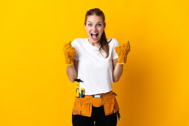 Mujer joven electricista en amarillo celebrando una victoria en la posición ganadora