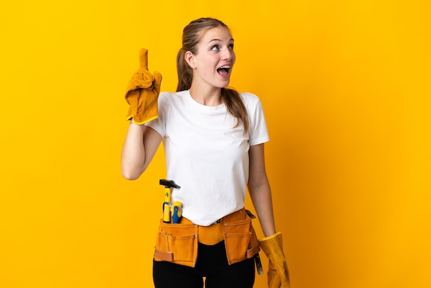 Mujer joven electricista en amarillo con la intención de darse cuenta de la solución mientras levanta un dedo