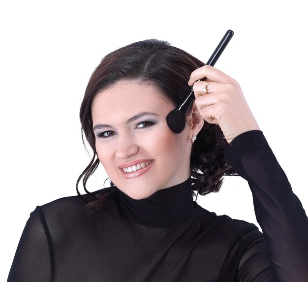 Mujer joven elegante con pincel para maquillaje