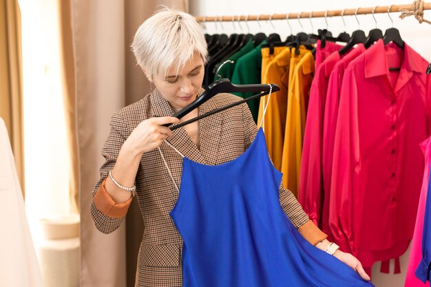 Mujer joven eligiendo ropa en la tienda