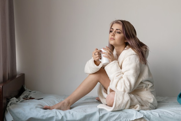 Mujer joven, en, ella, cama, en, un, albornoz