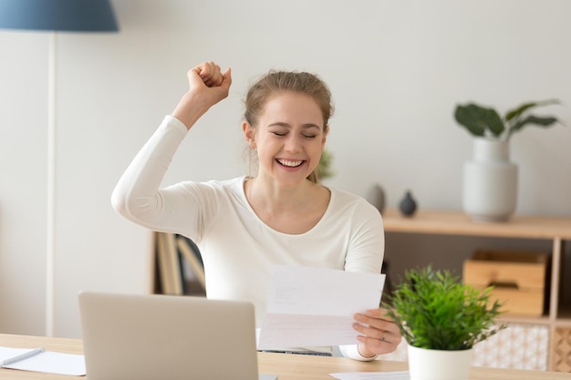 Foto mujer joven emocionada leyendo buenas noticias en el correo de papel feliz estudiante adolescente que recibe carta de admisión a la universidad buen resultado de la prueba de examen obtuvo un nuevo trabajo contratado celebrando la oportunidad en el aviso