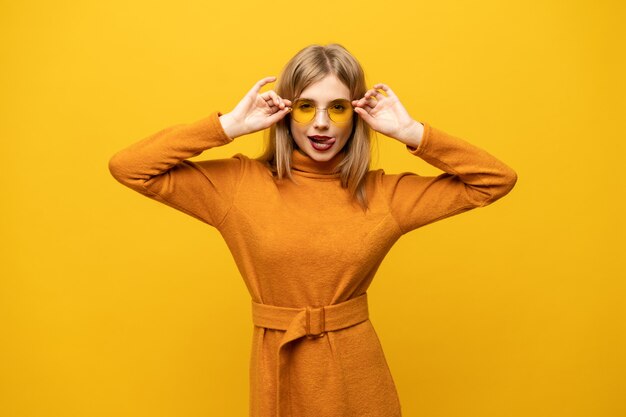 Mujer joven emocionada en vestido naranja, sonriendo ampliamente