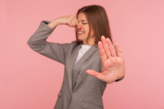 Mujer joven emocional en chaqueta sobre fondo rosa