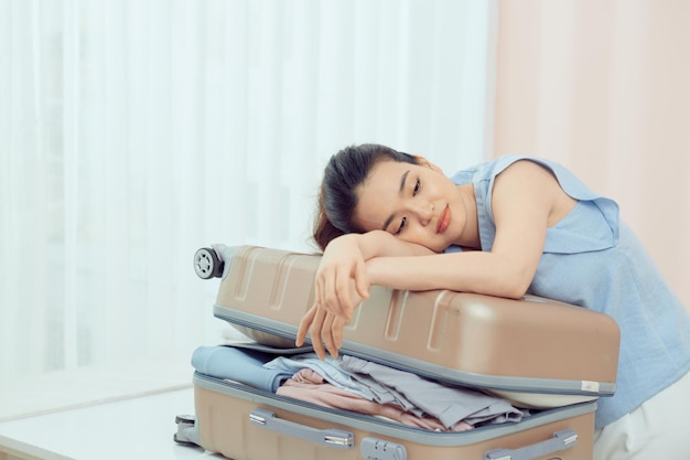 Una mujer joven empacando su maleta para el viaje a las vacaciones.