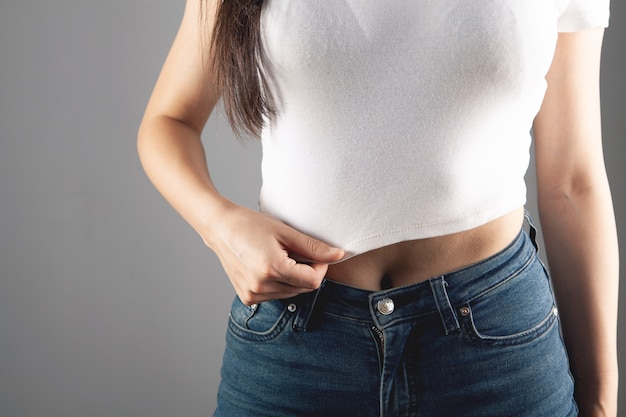 Mujer joven se encuentra en una camiseta corta y jeans