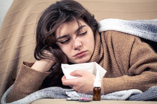 Mujer joven enferma con medicamentos se encuentra en cama resfriados y tratamiento en el hogar