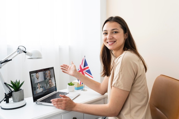 Mujer joven enseñando lecciones de inglés en línea en casa