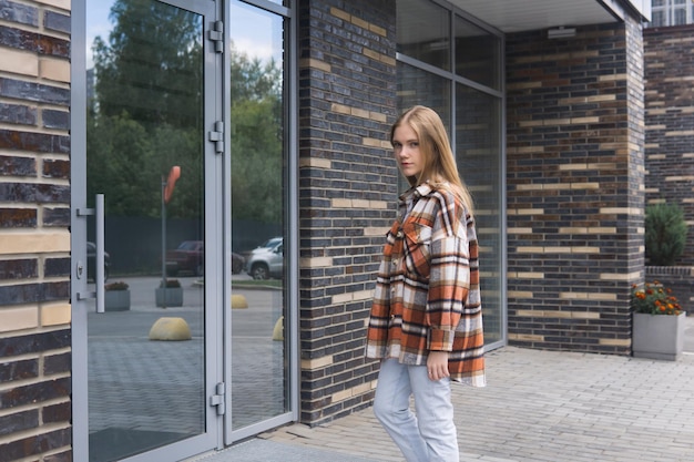 Mujer joven entra por la puerta de un edificio de la ciudad