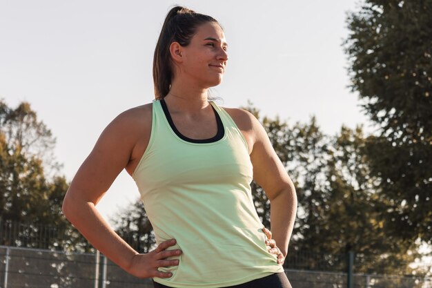 Mujer joven entrenando para comenzar la carrera en una pista del estadio afuera