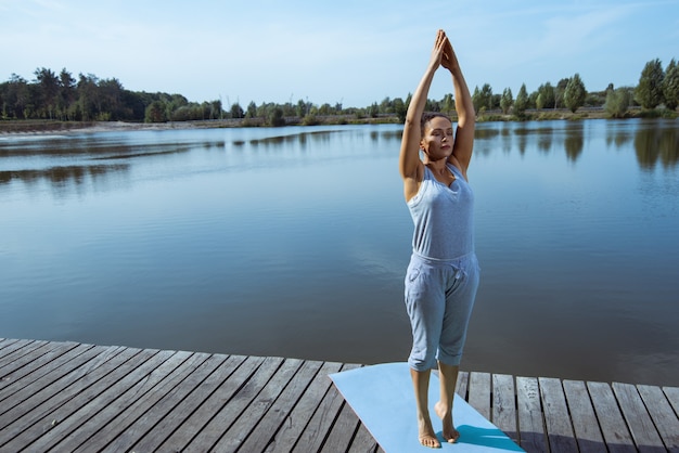 mujer joven entrenando junto al lago