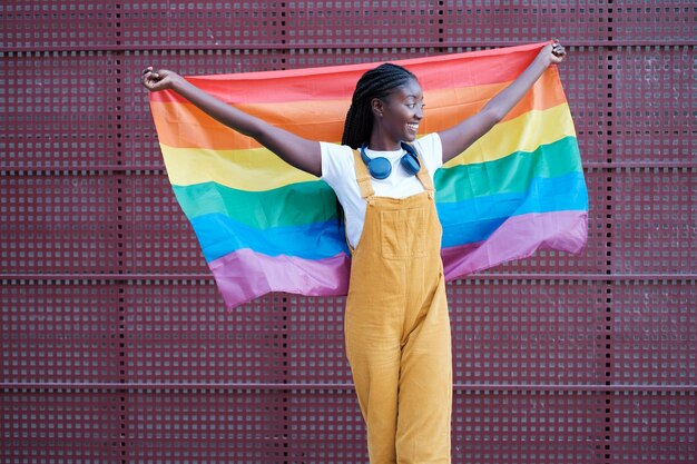 Mujer joven envuelta en la bandera del arco iris para luchar por los derechos de las LGBTI Concept Pride Lifestyle Fight