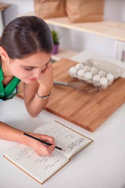 Mujer joven escribiendo algo en su bloc de notas