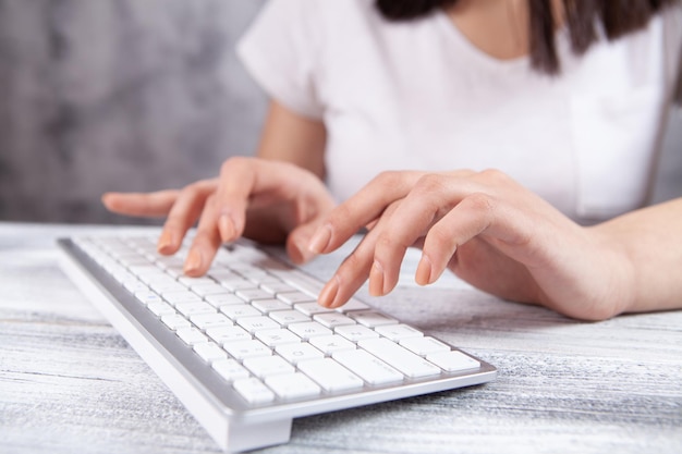 Mujer joven escribiendo en el teclado