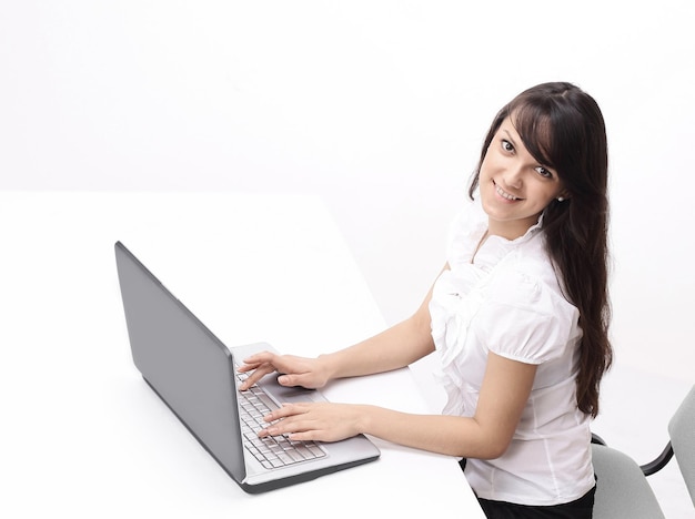 Mujer joven escribiendo texto en el teclado de la computadora portátil